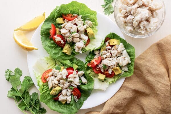 Assorted frozen crab meat displayed on a white plate among other seafood delicacies.