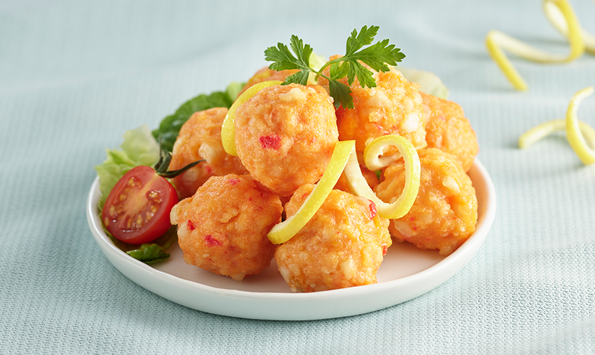 Golden fried lobster balls arranged on a white plate, showcasing their crispy exterior and succulent lobster filling.