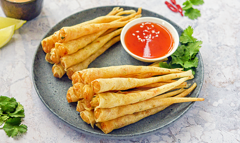 Shelled prawn twisters displayed on a white plate, showcasing their shape and golden-brown exterior.