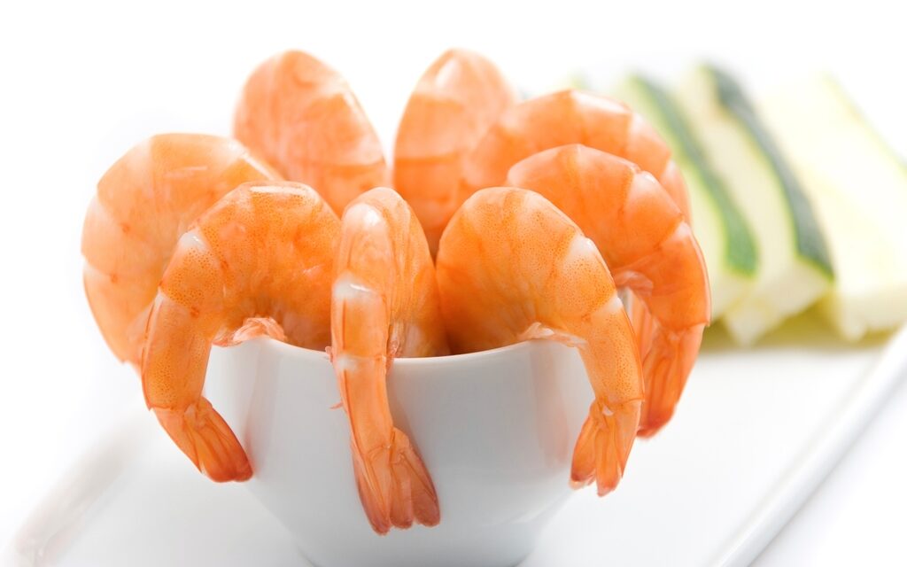 Cooked shrimp cutlets arranged on a white plate, showcasing their golden-brown exterior and succulent interior.